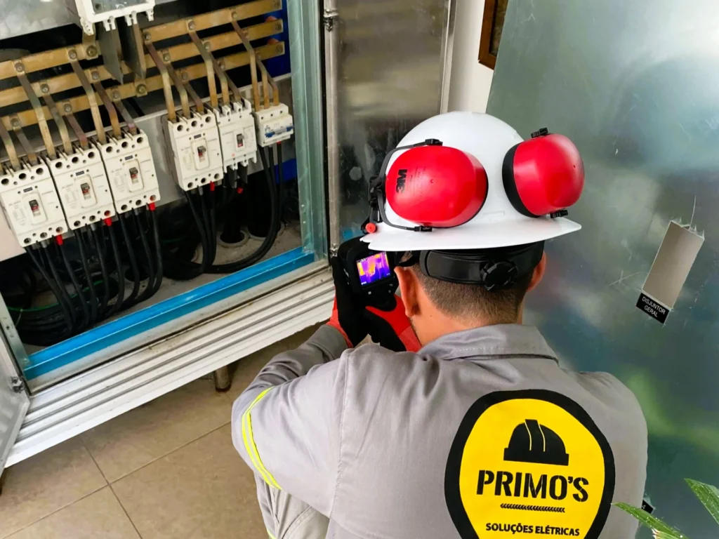 Técnico da Primo's realizando análise termográfica dos equipamentos de um quadro elétrico para análise de energia.